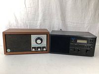 Pair of KLH radios side by side on white background showing the vintage wooden cabinet radio on left and modern black digital display radio on right