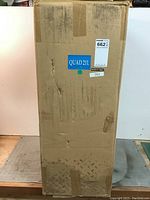 Front of cardboard box showing 'QUAD 21L' label, auction lot sticker '662' and green dot, sealed with tape