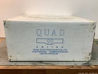 Front panel of shipping box showing QUAD 99 series logo and manufacturer name