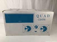 Front of cardboard box with QUAD CENTRE logo and graphic representation of speaker drivers