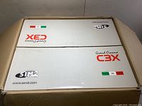 Top view of internal white box lid with Sim2 branding and Grand Cinema C3X logo
