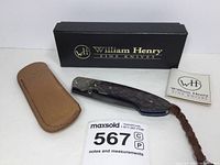 Knife, sheath, box, documentation and lanyard arranged together on white surface