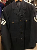 Front view of the dark navy blue Canadian Airforce jacket showing Airman rank patches on both sleeves and brass buttons.