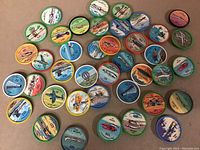Photo showing 40 vintage JELLO airplane collectible discs with various colorful aircraft illustrations and numbers, different designs, and multiple border colors.