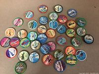 Photo showing all 40 assorted Jello airplane collectible discs laid out on a flat surface, each with different airplane illustrations and colored borders.