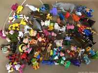 Top view showing a large assortment of colorful cartoon character figurines including animals and humanoid characters
