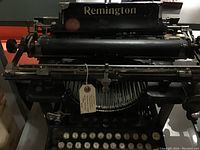 Close-up of the top back of the Remington typewriter showing the Remington name and the wide carriage design.