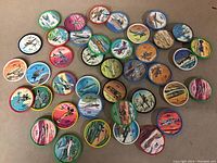 Photo showing 40 circular JELLO collectible airplane discs arranged on a flat surface, each with an image of an airplane and descriptive text, various colors of rims.