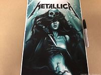 Full view of the Metallica art print laid flat with a marker for size comparison.