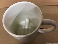 Photo showing inside the mug with the middle finger sculpture at the bottom.