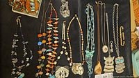 Assorted necklaces and bracelets laid out on black cloth
