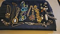 Overview of all necklaces and bracelets arranged on black cloth