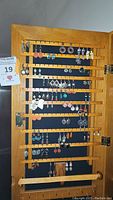 Wooden rack displaying multiple rows of dangling earrings