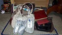 Wide shot showing multiple handbags and a pair of silver glittery sandals.