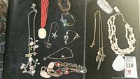 Overview of various sea and nature themed necklaces and bracelets laid out on dark fabric showing different materials like shell, metal, beads, charms.