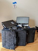 Photo of pile of electronic items including Panasonic Touch Book laptop, two laptop carrying cases, and various cables and accessories.