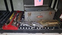 Metal Craftsman tool chest with various hand tools including screwdrivers, wrenches, sockets, and a plastic tool pouch inside.