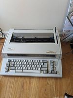 Front view of IBM Wheelwriter 1000 typewriter showing keyboard, numeric pad, and general body design