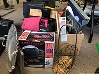 Overview photo showing boxed George Foreman grill, various kitchen and serving items packed in boxes and bags including metal basket and other utensils