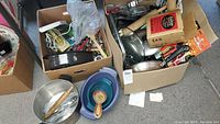Overall lot with various kitchen utensils, gadgets, and cookware in boxes and bowls including wood rolling pins and metal utensils