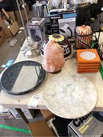 Full lot on table showing salt lamps, marble platters, various lamps and boxes