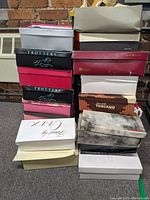 Stack of various shoeboxes containing women's footwear, mostly size 8, including brands Trotters and Toscano.