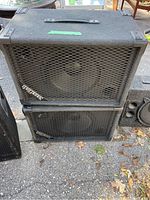 Two stacked Sound Tech event speakers with carpet casing and metal grille front, outdoors on pavement.