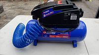 Side view of Campbell Hausfeld air compressor showing tank and coiled blue air hose