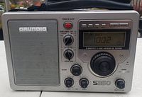 Front view of Grundig S350 shortwave world receiver showing speaker, digital frequency display, tuning knob, band selection, and audio control knobs.
