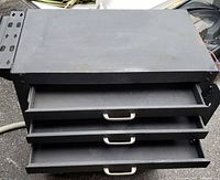 Front view of the tool cart showing the three drawers partially open and the top surface.