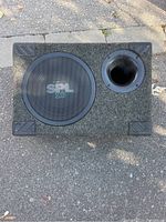Front view of carpeted Soundstream SPL10 subwoofer enclosure showing metal grille and bass port.