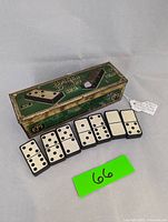 Dominoes laid out in front of the original green and gold decorative box labeled 'British Dominoes' No.2