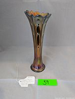 Full view of the antique pulled loop carnival glass vase, showing its flared and scalloped top and iridescent finish.