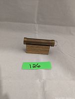 Brass teleidoscope horizontally mounted on a wooden stand with a green lot number card in front.