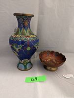 Photo of the cloisonné dragon vase standing beside the enameled footed bowl, both resting on a neutral fabric backdrop.