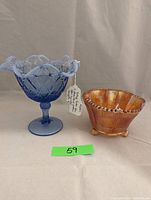 Blue Fenton glass compote with open lace edge and floral design, shown from side angle with tag