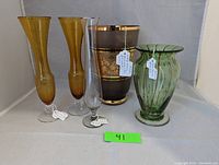 Group photo showing all five glass vases: two amber, one smokey glass with gold overlay, one green striped, and one etched bud vase.