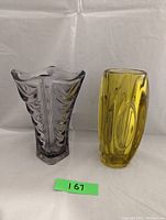 Photo of both vases side by side on white backdrop showing purple vase with textured design and yellow vase with oval impressions.