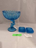 One photo shows the Indiana Glass lotus blue compote alongside the pair of Fenton hobnail salt cellars on a neutral background with auction tags.