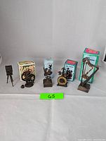 Lot of five vintage die-cast miniature pencil sharpeners displayed in a row against a white background, four with original boxes and one without box.