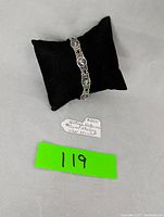 Full view of the vintage Siam nielloware sterling silver bracelet displayed on a black cushion with a handwritten note.