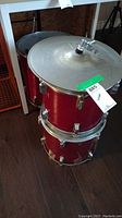 Two stacked red tom drums with a cymbal on top, chrome hardware, visible drumheads.