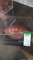 Wilson NFL football in a clear acrylic display case with visible white ink inscriptions dedicated to a Raiders fan and signed by Rod Martin #53.