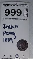 Image showing the 1889 Indian Head Penny alongside a label with the lot number and handwritten description.