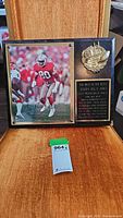 Full view of plaque showing signed photo of Jerry Rice, gold-tone emblem, and engraved plaque with career highlights.