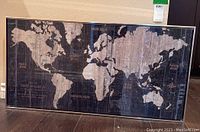 Full view of framed world map showing entire world map with continents and oceans labeled on a wooden plank style background.