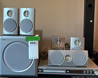 Full unit view showing subwoofer, four satellite speakers placed on and around the subwoofer, and Philips DVD player beneath subwoofer