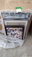 Stack of framed sports photos wrapped in bubble wrap, showing the size and condition of the lot