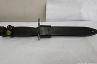 Side view of the bayonet with black M10 plastic scabbard.