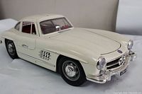 Front left side view of a white Burago Mercedes 300SL model car showing detailed exterior and chrome accents.